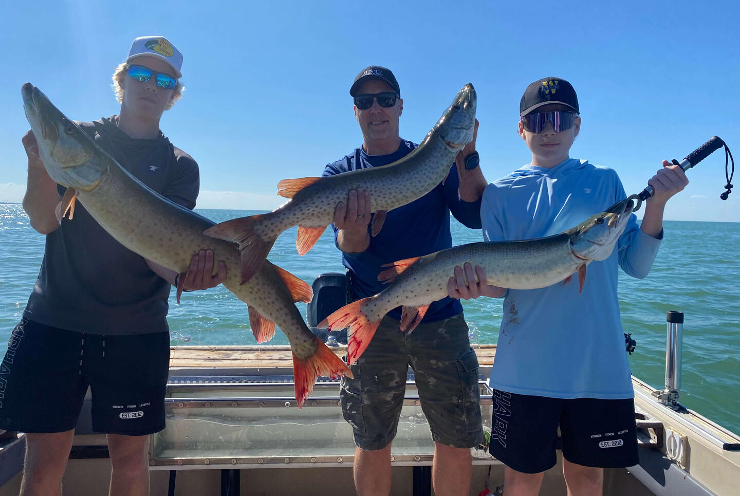 Big Musky Catch Family holding their trophy musky caught near Tilbury, Ontario